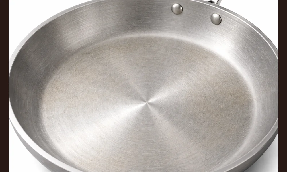 Bare aluminum cookware surface showing normal discoloration from use