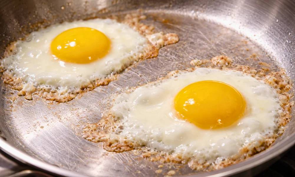 Eggs adhering to stainless steel surface due to early protein interaction