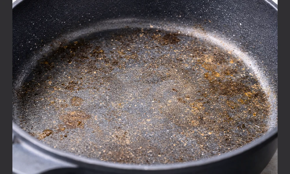 Worn ceramic cookware surface showing reduced nonstick performance without peeling