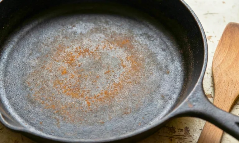 Light surface rust visible on iron cookware showing gradual oxidation
