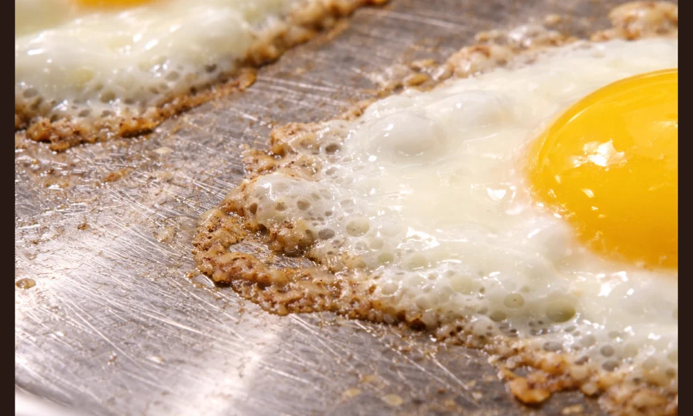 Close-up of stainless steel surface texture affecting egg protein adhesion
