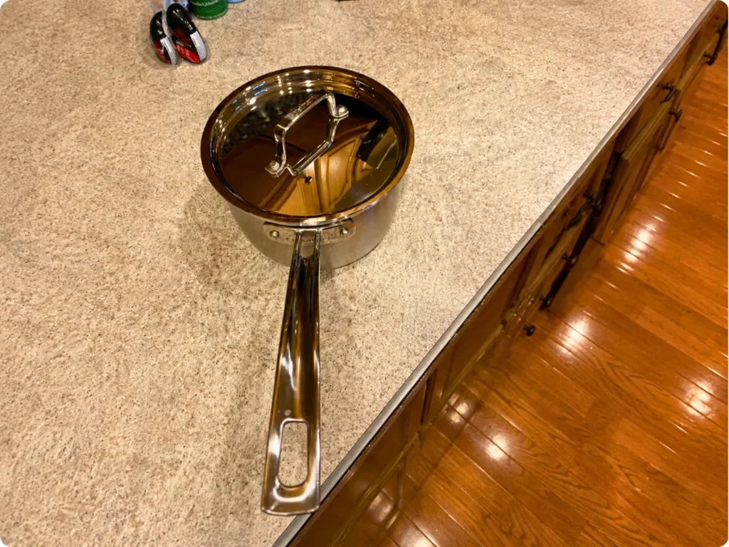 Cuisinart MultiClad Pro saucepan showing the riveted stainless steel handle and lid